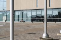 a parking meter is in front of a building with glass walls and columns on the side