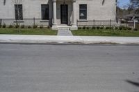 a building with the door open and on the sidewalk behind it is an empty street