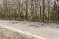 the asphalt road has been paved with trees and grass along both sides of it on either side