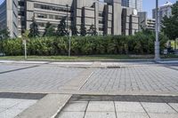 a person sitting at the bench in front of a mall that is empty of people