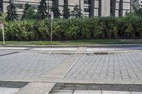 a person sitting at the bench in front of a mall that is empty of people