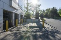 the sun is shining over a building with parking meters and poles in front of it