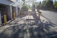 the sun is shining over a building with parking meters and poles in front of it