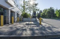 the sun is shining over a building with parking meters and poles in front of it