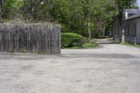 a fire hydrant sitting next to a tall wooden fence and wall next to the road