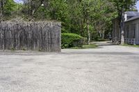 a fire hydrant sitting next to a tall wooden fence and wall next to the road