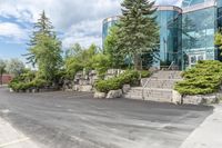 a parking lot that has trees and rocks along side it with steps and stairs in the center