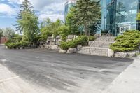 a parking lot that has trees and rocks along side it with steps and stairs in the center