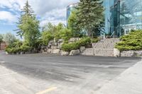 a parking lot that has trees and rocks along side it with steps and stairs in the center