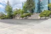 a parking lot that has trees and rocks along side it with steps and stairs in the center