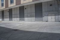 there is an empty sidewalk in front of buildings that are lined with garages and shutter