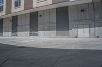 there is an empty sidewalk in front of buildings that are lined with garages and shutter