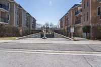 the street with several apartment buildings near it in a residential area of a city on a sunny day