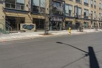 a empty street that has shops and stores on the side of it and a traffic light in the middle of the road