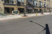 a empty street that has shops and stores on the side of it and a traffic light in the middle of the road