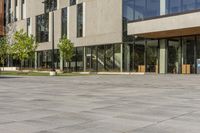 the building is glassy in the windows and has a bench next to it on the sidewalk