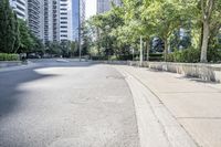 a car driving down an empty street lined with tall buildings and trees in the background