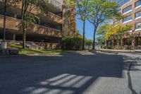 a big brick building that is on a street corner near some trees and other buildings