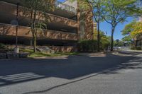 a big brick building that is on a street corner near some trees and other buildings