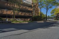 a big brick building that is on a street corner near some trees and other buildings