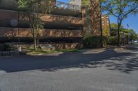 a big brick building that is on a street corner near some trees and other buildings