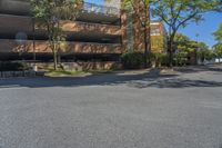 a big brick building that is on a street corner near some trees and other buildings