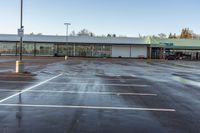 an empty parking lot with no people outside of the store, in late afternoon sun