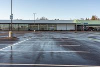 an empty parking lot with no people outside of the store, in late afternoon sun