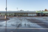 an empty parking lot with no people outside of the store, in late afternoon sun