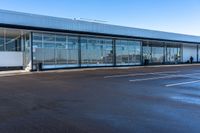 an empty parking lot that includes some glass windows and a wall that says an airplane