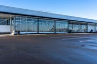 an empty parking lot that includes some glass windows and a wall that says an airplane