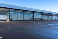 an empty parking lot that includes some glass windows and a wall that says an airplane