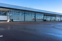 an empty parking lot that includes some glass windows and a wall that says an airplane