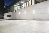 the large concrete wall has been illuminated by recessed lights at night on either side of it