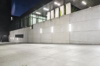 the large concrete wall has been illuminated by recessed lights at night on either side of it