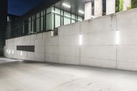 the large concrete wall has been illuminated by recessed lights at night on either side of it