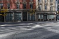 a building on the street that has two windows with no cars parked on it and there are yellow lights