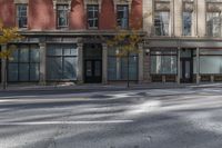 a building on the street that has two windows with no cars parked on it and there are yellow lights