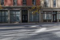 a building on the street that has two windows with no cars parked on it and there are yellow lights