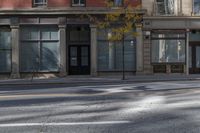 a building on the street that has two windows with no cars parked on it and there are yellow lights