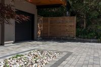 a patio in front of the garage with large brick pathway and water feature on the concrete