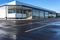 the empty parking lot in front of a building on a sunny day, with no people around it