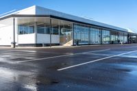 the empty parking lot in front of a building on a sunny day, with no people around it