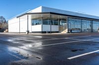 the empty parking lot in front of a building on a sunny day, with no people around it