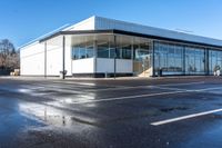 the empty parking lot in front of a building on a sunny day, with no people around it