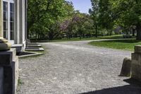 a pathway leads to a park with trees in the background and benches on the far side