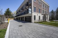 a car garage sits next to a three story brick building with a balcony that is open