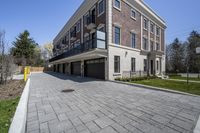 a car garage sits next to a three story brick building with a balcony that is open