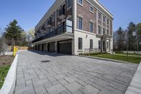 a car garage sits next to a three story brick building with a balcony that is open