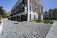 a car garage sits next to a three story brick building with a balcony that is open